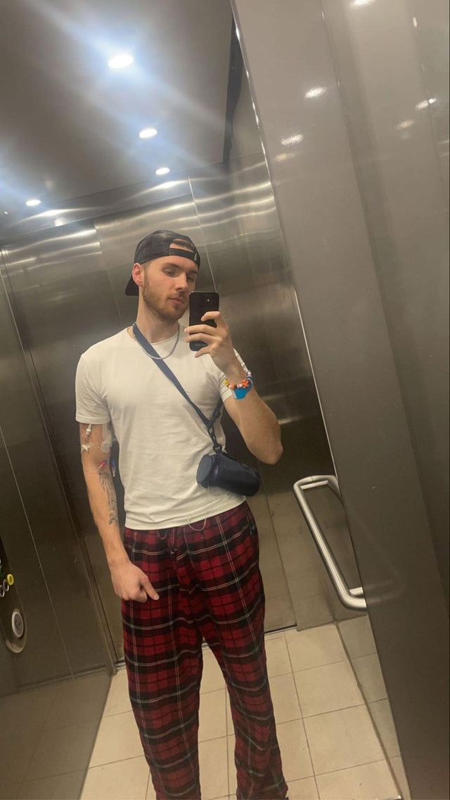 En person står i en hiss och fotar en selfie i hissens spegel.